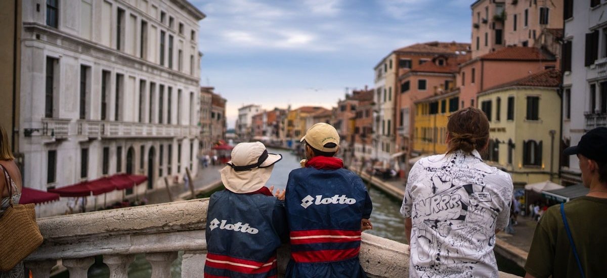 Man & Woman standing in Venice with vintage lotto Clothing